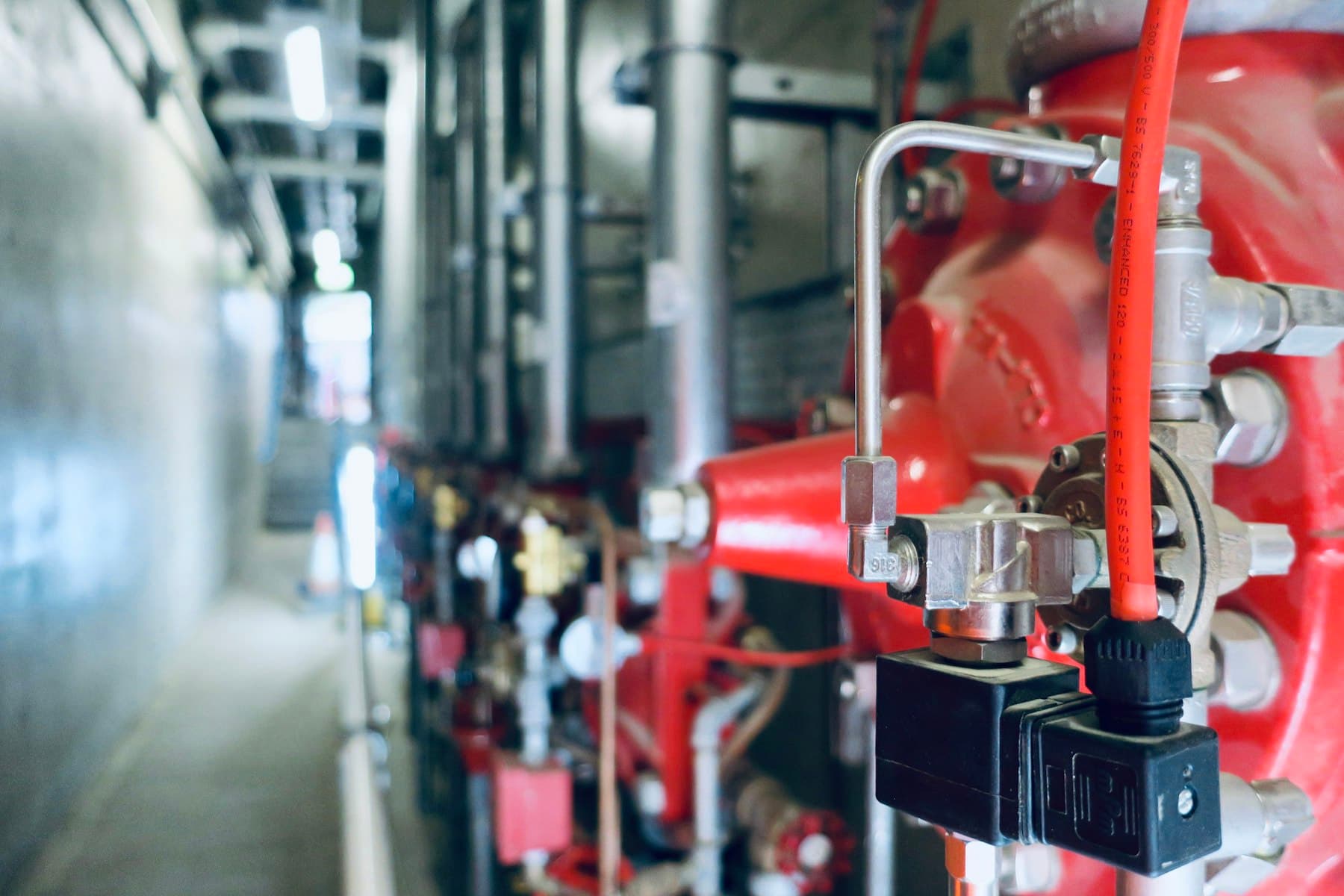 Valve assemblies and pipework in a plant room corridor